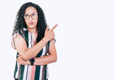 Güzel afro genç bir kadın reklamını sağa sola doğrultuyor. Şaşkın gözlüklü kız yan taraftaki afişi gösteriyor.