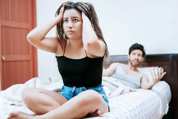 stock image Young couple arguing sitting on the bed. Concept of couple problems in bed. Upset woman with husband sitting on bed, Wife arguing with her husband in bed