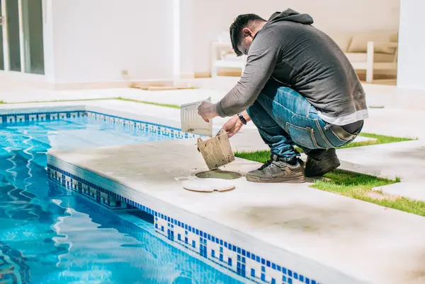 stock image Man cleaning swimming pool garbage filter. Worker removing trash from swimming pool filter basket