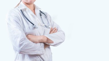 Kolları fotokopi aletiyle bağlanmış tanınmayan bir kadın doktor. Çapraz kollu tıp doktoru pankartı.