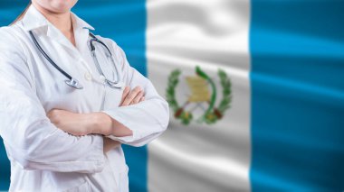 Arka planda Guatemala bayrağı olan sağlık konsepti. Kolları Guatemala bayrağı ile çaprazlanmış bir doktor.