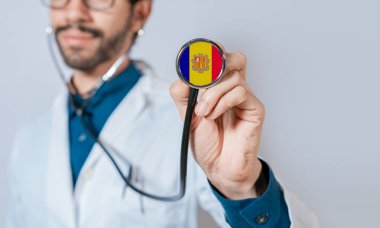 Doktor, Andorra bayrağıyla steteskop tutuyor. Andorra Sağlık ve Bakım Konsepti, steteskopta Andorra bayrağı