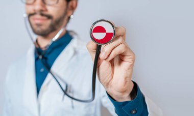 Grönland bayrağıyla steteskop tutan doktor. Grönland Sağlık ve Bakım Konsepti, steteskopta Grönland bayrağı