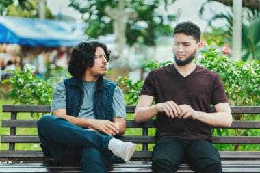 İnsanların yanında sigara içen bir adam. Sigara içen ve nefes veren bir adam, yanındaki kişiye duman üflüyor.