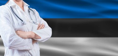 Estonya bayrağında çapraz kollu doktor. Estonya Sağlık ve Bakım Konsepti. Estonya Bayrağında Kadın Doktor