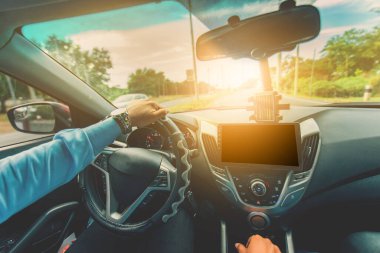 Sürücü elleri asfaltta sürerken direksiyonda. Otobanda sürücünün elleri görünüyor.