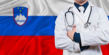 Slovenya bayrağında steteskopu olan bir erkek doktor. Slovenya bayrağında steteskop tutan doktor