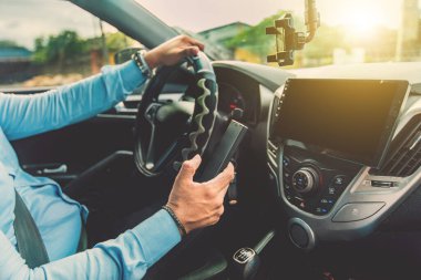 Cep telefonu kullanırken direksiyondaki şoför. Araba kullanırken telefonu kullanan bir adam. Sorumsuz sürüş kavramı