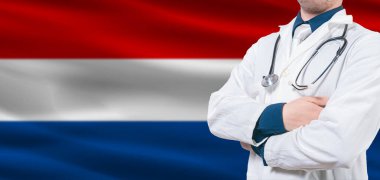 Hollanda sağlık hizmetleri konsepti. Hollanda bayrağında erkek doktor. Hollanda bayrağında çapraz kollu doktor