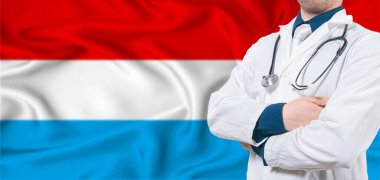 Lüksemburg sağlık hizmeti konsepti. Lüksemburg bayrağında erkek doktor. Lüksemburg bayrağında çapraz kollu doktor