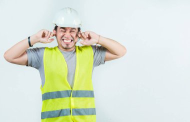 Kulakları yalıtılmış genç mühendis. Kulak ağrısı olan erkek mühendis.