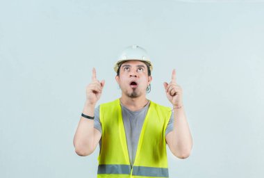 Şaşırmış genç inşaatçı, izole edilmiş. Şaşkın inşaat işçisi işaret ediyor