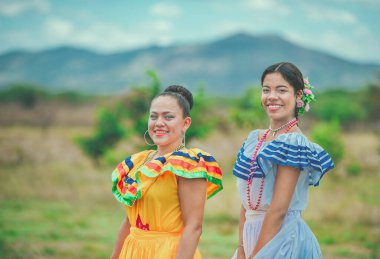Kültürel folklorik kostümler giyen iki gülümseyen İspanyol kız. Tarlada kültürel folklorik kostüm giyen iki İspanyol kadının portresi