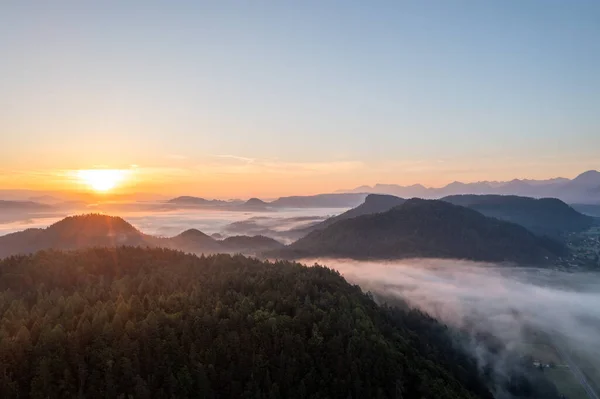 渓谷の霧と早朝の山々の日の出 ロイヤリティフリーのストック画像