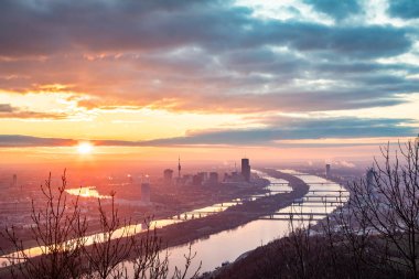 Gündoğumunda Viyana, Avusturya 'nın çarpıcı panoramik manzarası, şehrin siluetini, Tuna Nehri' ni ve birden fazla köprüyü gözler önüne seriyor..