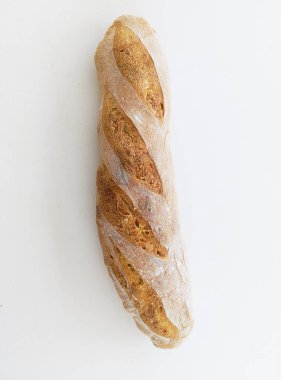 Ahşap fırında elle yapılmış bir somun ekmek. Doğal ışık ve beyaz arkaplan ile dikey çekim.