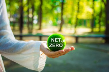 Çevre, sosyal ve yönetim (ESG) değerlerini yansıtan, daha yeşil bir gelecek için net sıfır kavramını teşvik eden, yeşil bir top tutan, sürdürülebilir bir yaşam.