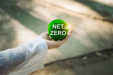 Çevre, sosyal ve yönetim (ESG) değerlerini yansıtan, daha yeşil bir gelecek için net sıfır kavramını teşvik eden, yeşil bir top tutan, sürdürülebilir bir yaşam.