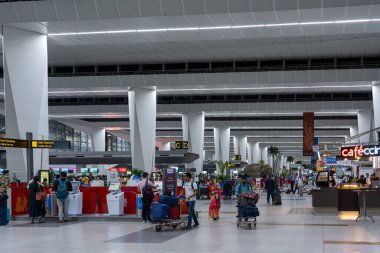 Delhi, Hindistan - 31 Mart 2023: Indira Gandhi Uluslararası Havalimanı 'ndaki salonda bir grup insan