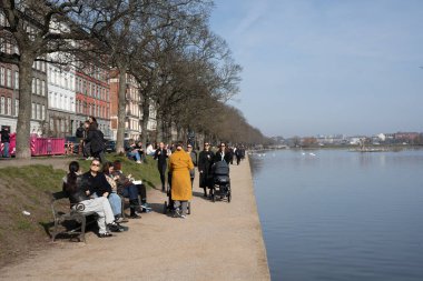 Kopenhag, Danimarka - 8 Mart 2025: Güneşli bir günde insanlar Göller boyunca yürüyüş yapıyor.