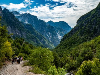 Hikers in the mountains in Theth valley in Albania clipart