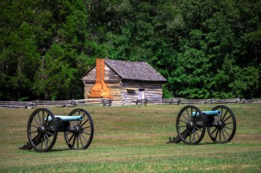 Mavi bir M1857 12-Pounder, Napolyon, Shiloh Ulusal Askeri Parkı 'nda bir Amerikan iç savaş topu. Eski ahşap bir kulübeyle