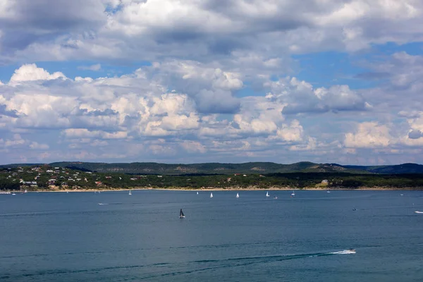 stock image Sailboats and motorboats on the clear blue waters of Canyon Lake in Texas. With beaches, sand, trees and partly cloudy blue sky's.