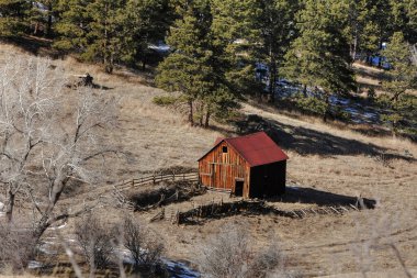 Dağda terk edilmiş eski bir ahır. Etrafında kırık ahşap çitler var..