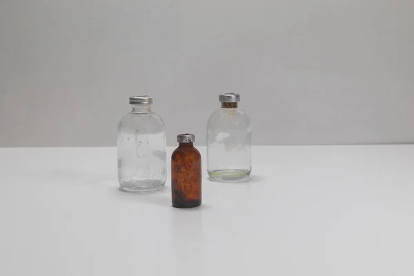 Zwei Alte Klare Impfstoffflaschen Und Eine Bernsteinfarbene Impfstoffflasche Gealtert Und — Stockfoto