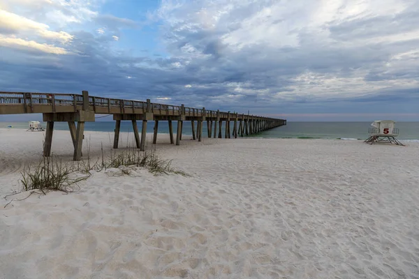 stock image Pensacola Beach Fishing Pier extending out into the Gulf of Mexico during a pastel colored sunset sunset on a cloudy evening. 