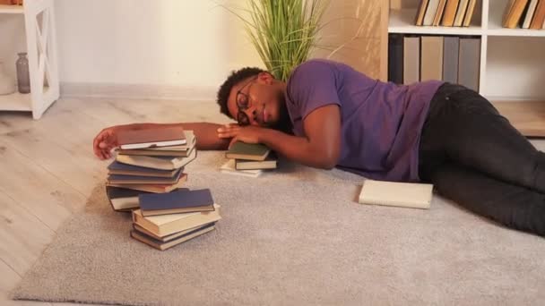学习疲劳 在家学习休息 加强教育 厌倦了懒惰的男生在现代客厅的地板上和书堆小睡 — 图库视频影像