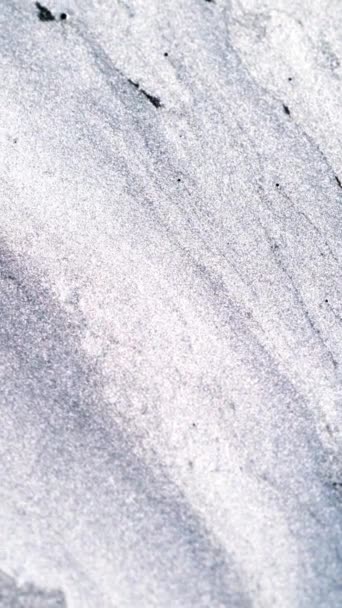 垂直录像 雪融化了冰的抽象背景 冬天的雪崩单色浅白灰闪烁的油墨在粗糙平面的水中流动 用红色电影摄影机拍摄 — 图库视频影像
