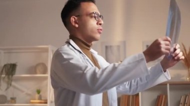 Göğüs muayenesi. Radyolog işi. Profesyonel travmatoloji kontrolü. Kafası karışmış erkek doktor X-ray filmlerini inceliyor..