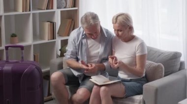 Seyahat planı. Endişeli çift. Tatil ilhamı. Orta yaşlı bir adam ve kadın seyahat listesi hazırlıyorlar. Bagaj lambasının içinde oturuyorlar..