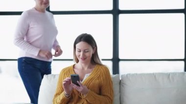 Aile sırrı. - Kadın ilişkisi. Dijital hayat. Gülümseyen anne, kızını uyurken yakalıyor. Akıllı telefonuyla ışık odası içinde mesaj yazıyor..