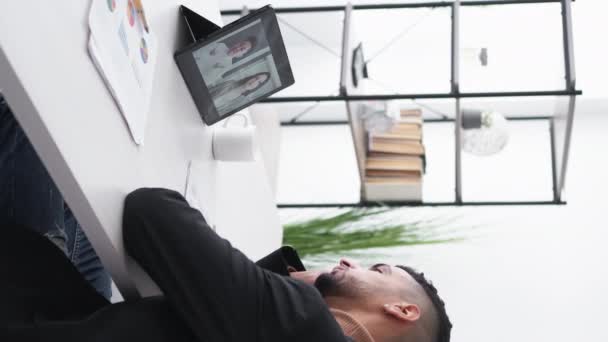 垂直ビデオ 退屈なレッスンだ 寝てる男だ 仮想接続 疲れ男Yawningオンライン会議を持っている手の上に頭を敷設タブレットコンピュータの光の部屋のインテリア — ストック動画