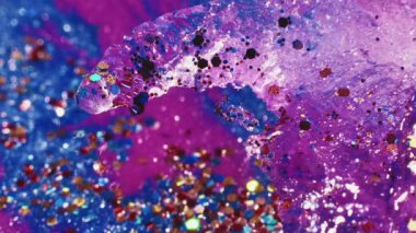 Sıvı büyüsü. Parlak akış sanatı. Şenlik arka planı. Şeffaf ışıldayan sıvı boya akışı ve makro ateş içinde yüzen rengarenk çıngıraklar..