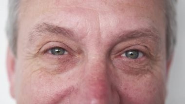 Oftalmoloji kontrolü. Mutlu yaşlı adam. Görsel odaklanma. Pozitif yaşlı, mavi gözlü, düz duran, beyaz, dağınık yüzlü bir erkek..