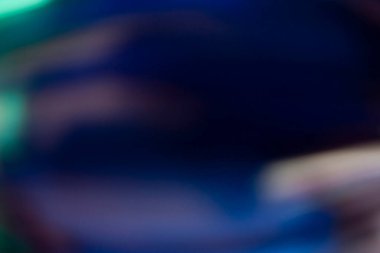 Mercek alevi kaplaması. Işık sızıntısı. Bulanık parıltı. Odaklanmamış neon mavisi turuncu renk koyu siyah kopya alanı arkaplanındaki deseni lekeler.