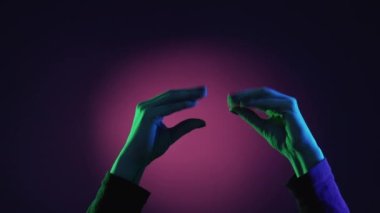 Bla-bla hareketi. Yanlış sözler. Tiyatro kavgası. Kadın elleri, neon ışıklı, mor yeşil arka planda konuşuyormuş gibi yapıyor..