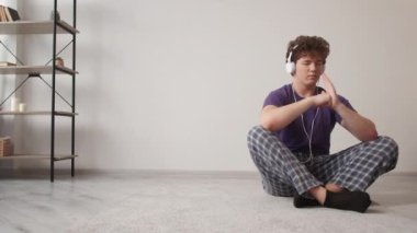 Müzik ilhamı. Rahat adam. Meditasyon sporu. Rastgele sakin adam kulaklıklarla bak. Kapalı gözler. Karate pozisyonu ışık odası iç mekânında eller..