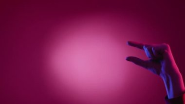 Ölçme jesti. Farklı boyutlarda. Görsel işaret. Kadın elleri küçük ve büyük miktarlarda, parmakları açık pembe arkaplanda..