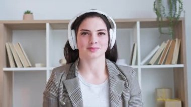 Çevrimiçi öğretmen. E-öğrenme toplantısı. Uzaktan eğitim. Sanal sınıfta konuşan, kulaklıklı neşeli bayan koç. Uzun video çekimi.