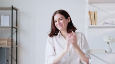 İş promosyonu. Sanal arama. Mesafe kutlaması. İlerleme selamlaması. Memnun iş kadını modern ofis içini alkışlıyor..