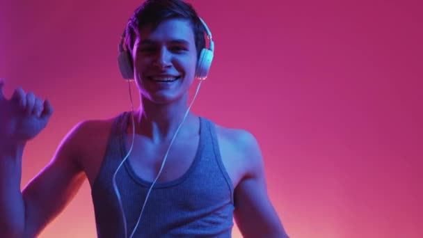 Tanzender Mann Porträt Neonlicht Stereoton Glücklicher Lustiger Kerl Mit Kopfhörern — Stockvideo