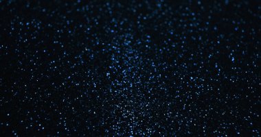 Bokeh parıldıyor. Işıldayan arka plan. Göz kamaştırıcı bir parlaklık. Odaklanmamış mavi renk parlak ışık parçacıkları deseni koyu siyah soyut kopya duvar kağıdı üzerinde.