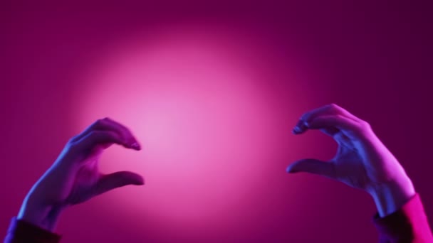 ハートジェスチャー 表情だ 視覚的なサインだ ネオンライトピンクブルーの背景に愛の表現図を作成一緒に保持する女性の手 — ストック動画