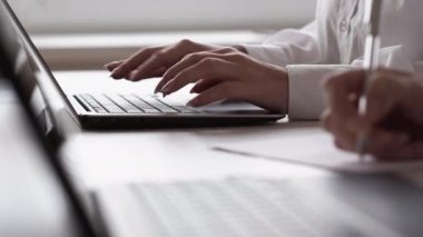 Ofis işleri. İnternet işi. Şirket yazışmaları. Tanımlanamayan bayan meslektaşlar dizüstü bilgisayarda yazı yazıp iş yerinde not alıyorlar..