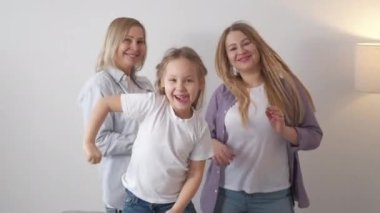 Mutlu bir aile. Kadın nesli. Keyif alıyorum. Neşeli kız anne ve büyükanne dans ediyor, ışık odasında eğleniyorlar..
