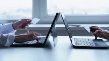Çevrimiçi bankacılık. Elektronik işlem. E-ticaret transferi. Tanımlanamayan kadın ofis çalışanları, iş yerinde nakit ödeme için kredi kartı laptopunu kullanıyorlar..